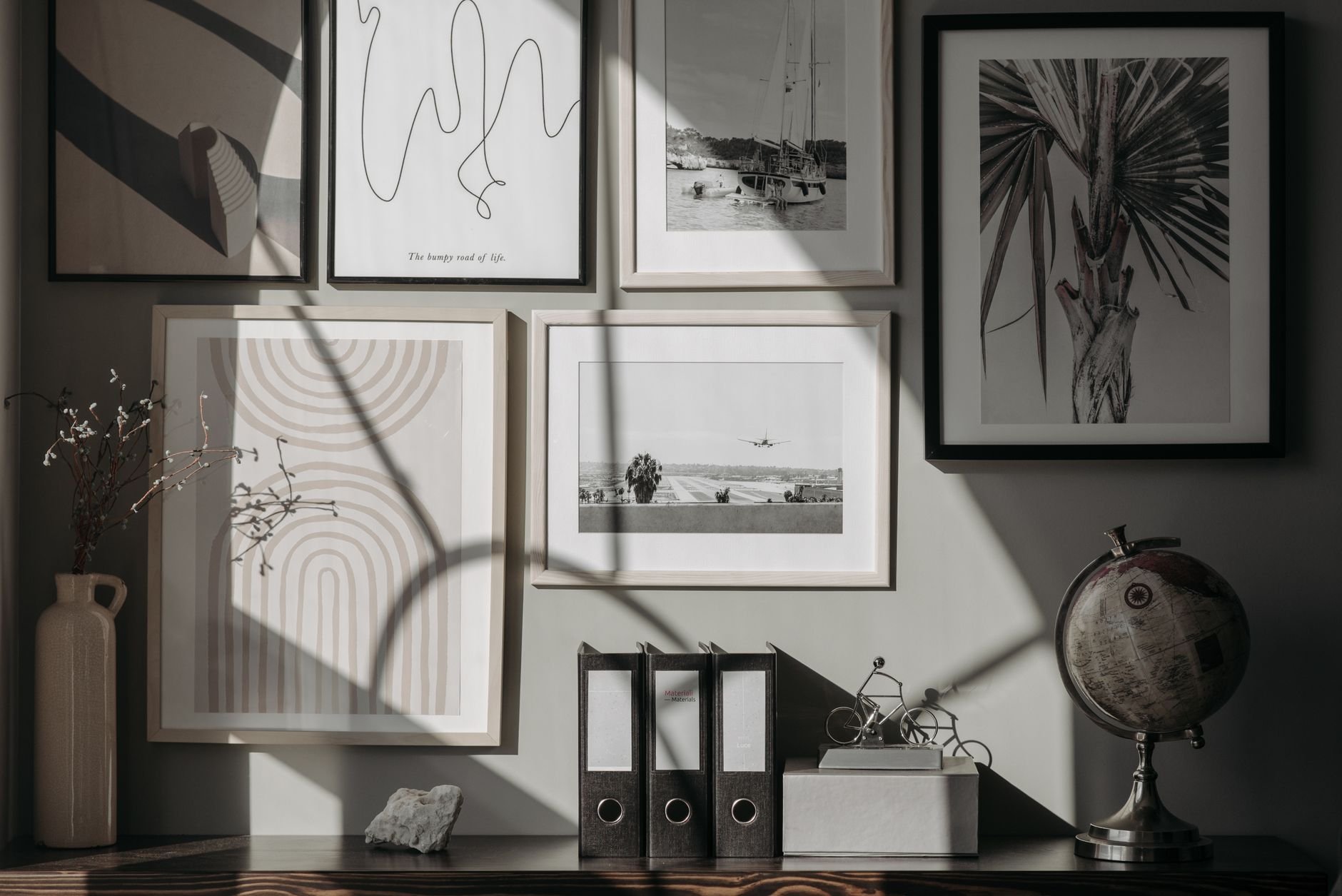 Framed art prints displayed on a warm wooden surface with soft interior lighting
